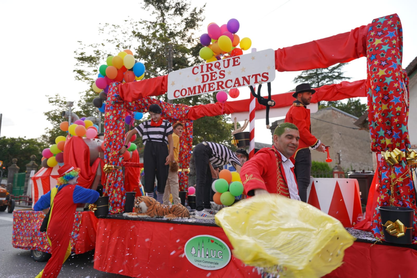 un char nommé "le cirque des commerçants" ; il est rouge, décoré de ballons, de couleurs vives et des figurants déguisés en clowns y font la fête